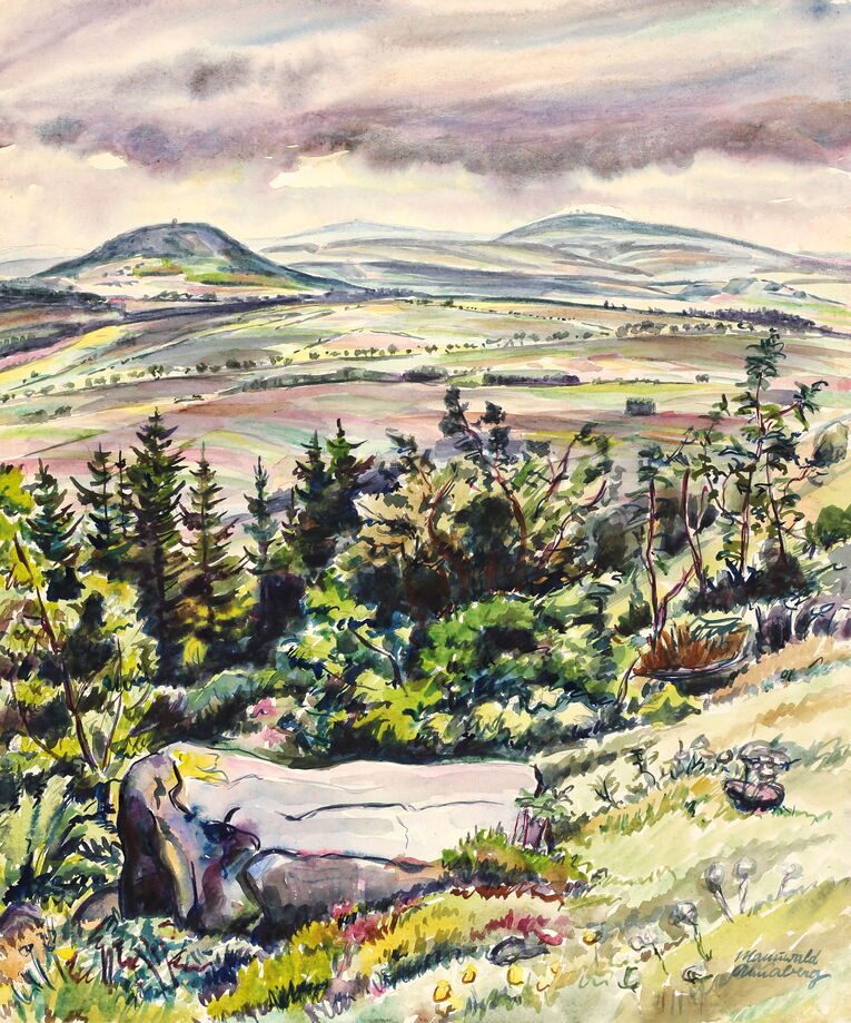 Rudolf Manuwald, Am Pöhlberg, 1940er Jahre. Aquarell mit einem Blick über Wiesen und Felder auf den Bärenstein, den Keilberg und den Fichtelberg im Hintergrund, im Vordergrund ein Wiesenhang mit Blumen und einem Felsbrocken, dahinter Büsche und Bäume
